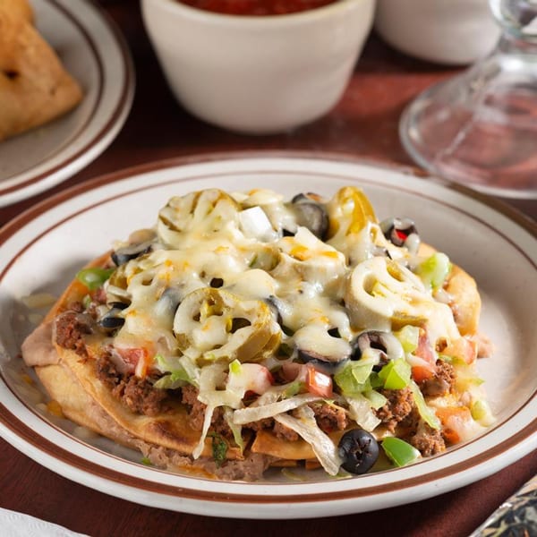 A Pancho Villa's Mexican pizza with melted cheese, ground beef, olives, jalapeños, and vegetables.