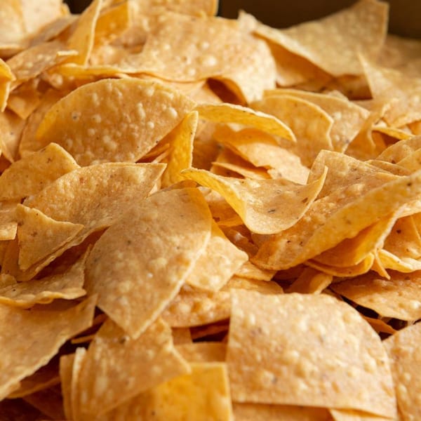 Close-up of a large pile of crispy, golden tortilla chips, perfect for Pancho Villa's Mexican cuisine.